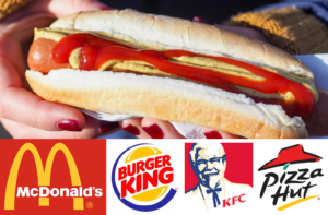 Close up of hands holding a hotdog with ketchup and mustard