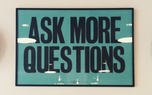 The words ask more questions as a framed picture on a wall